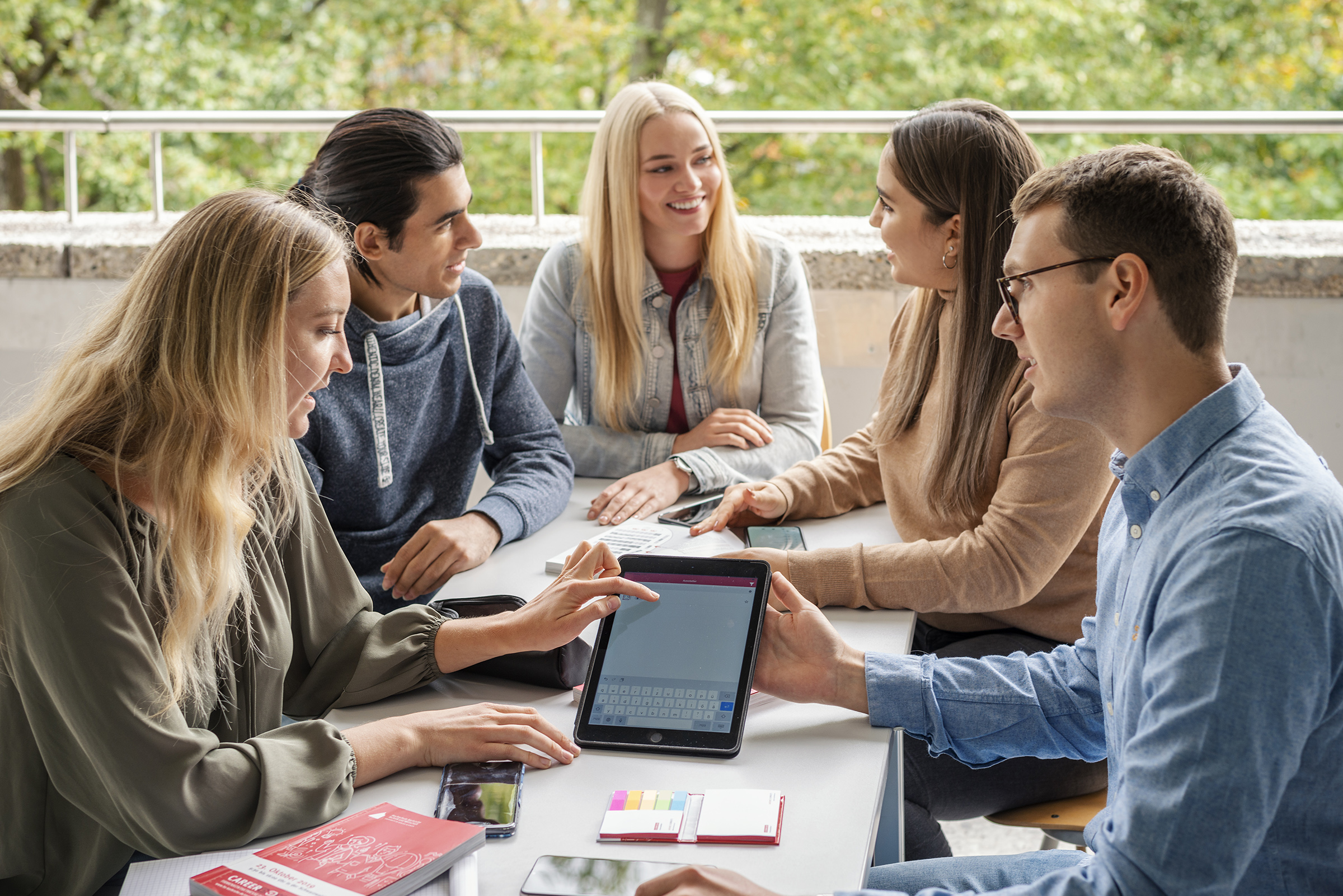 Group of students sitting around a table and working together Group of students sitting around a table and working together