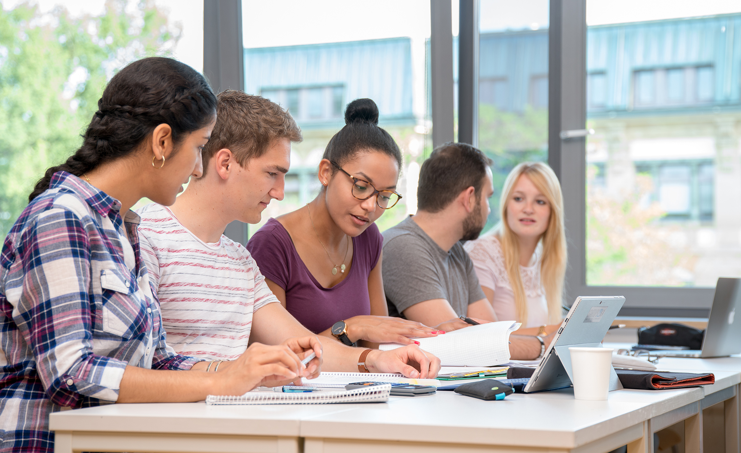 A working group of international students sitting at a table A working group of international students sitting at a table