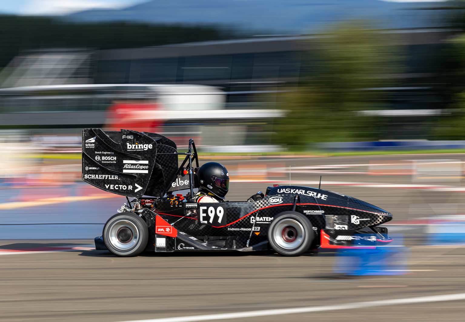 student in the racing car driving along the track student in the racing car driving along the track
