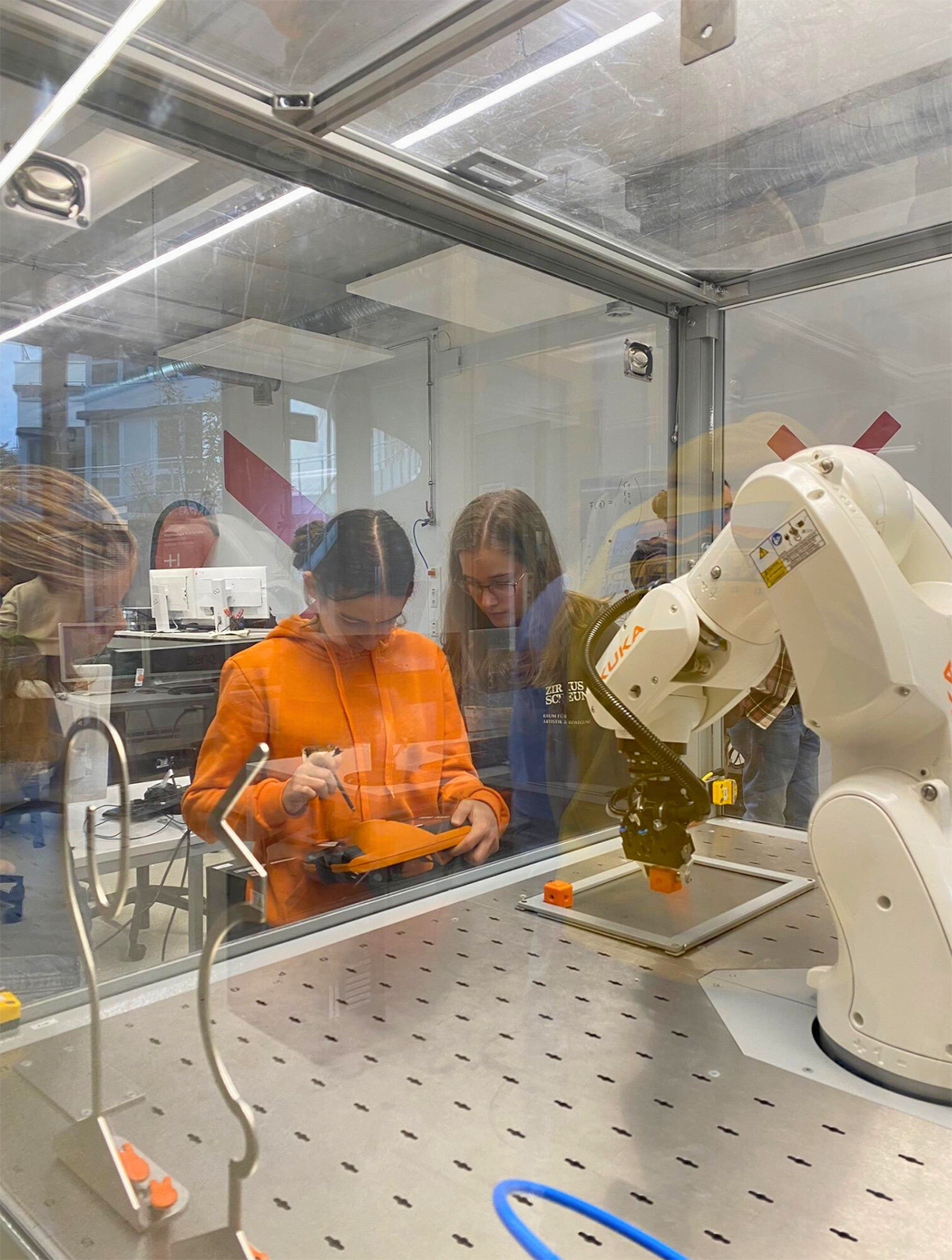 machine tool in glass enclosure, with pupils busy programming machine tool in glass enclosure, with pupils busy programming