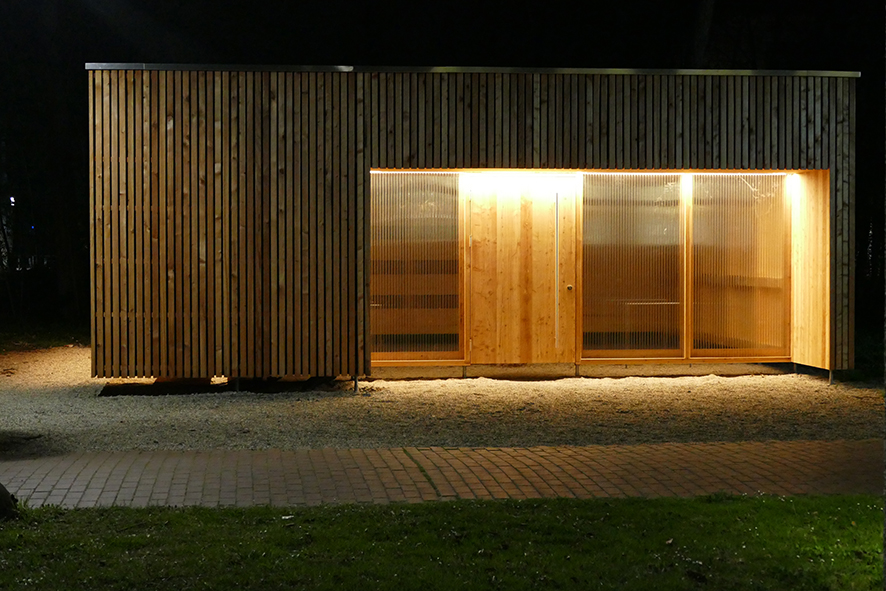 brightly lit wooden shed at night