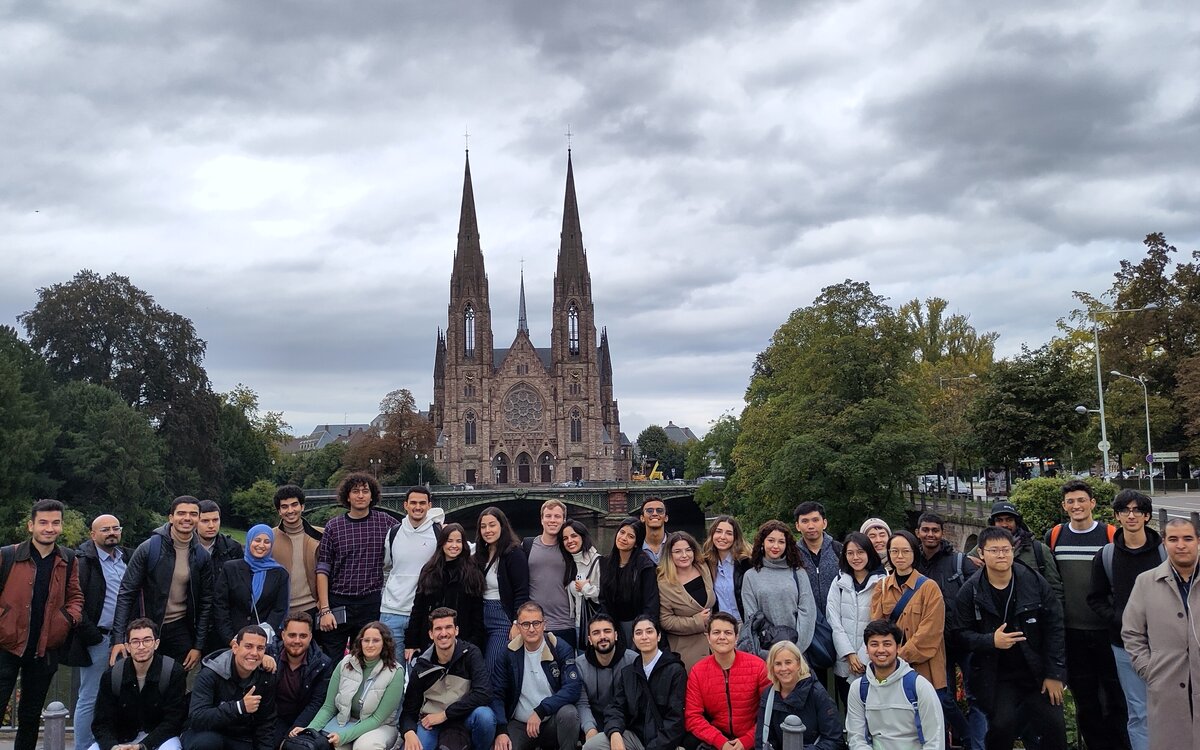 A group of 30 students is standing in front of a church in Strasbourg
