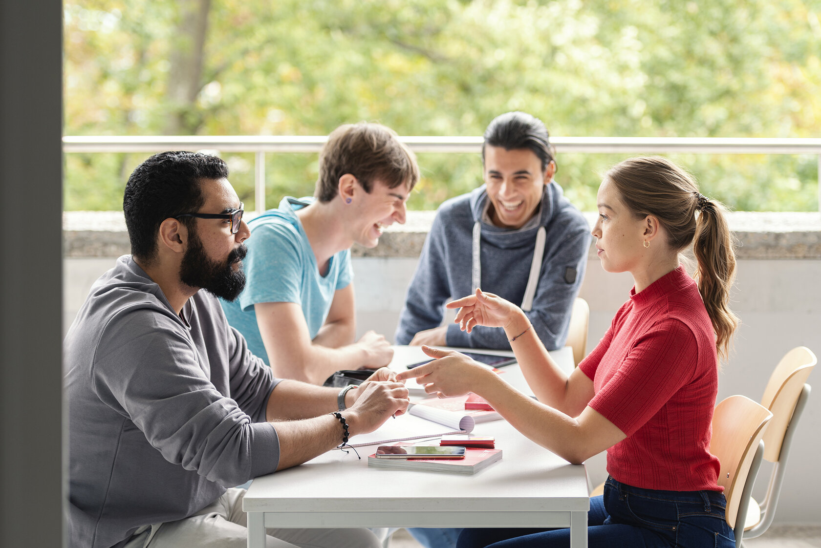 workgroup of four laughing students sitting at a table workgroup of four laughing students sitting at a table