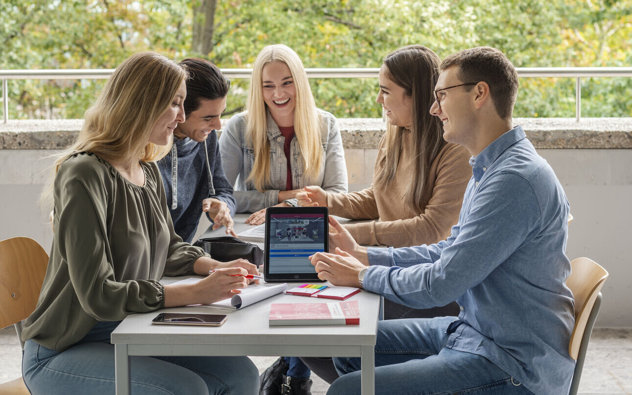 Gruppe Studierende am Tisch auf dem Balkon