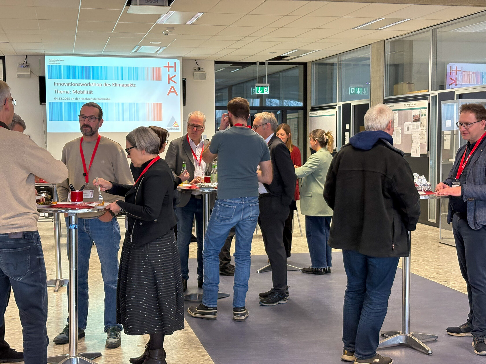 Besucher und Besucherinnen stehen beisammen und unterhalten sich.