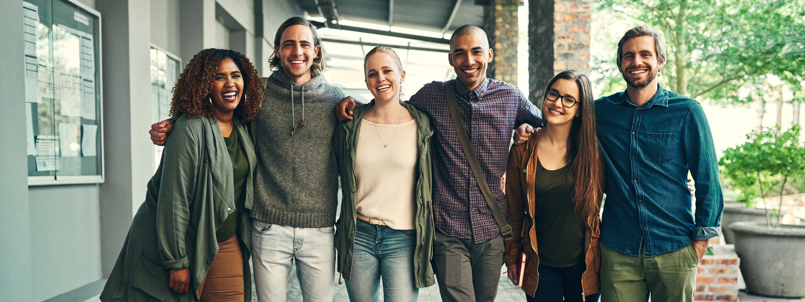 Mixed group of students embracing and smiling at the viewer Mixed group of students embracing and smiling at the viewer