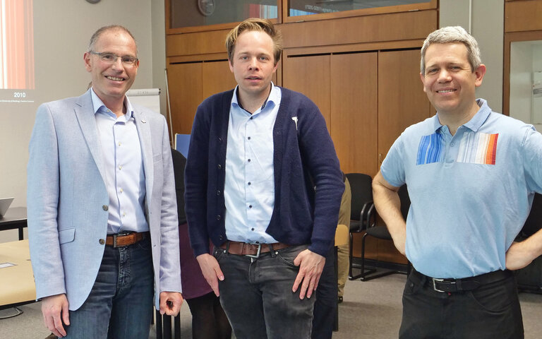 Rektor Prof. Dr. Frank Artinger (l.) und Prof. Dr. Olivier Schecker (r.) begrüßen Rasmus Andresen, Mitglied des Europäischen Parlaments, zum Klima-Puzzle an der Hochschule Karlsruhe