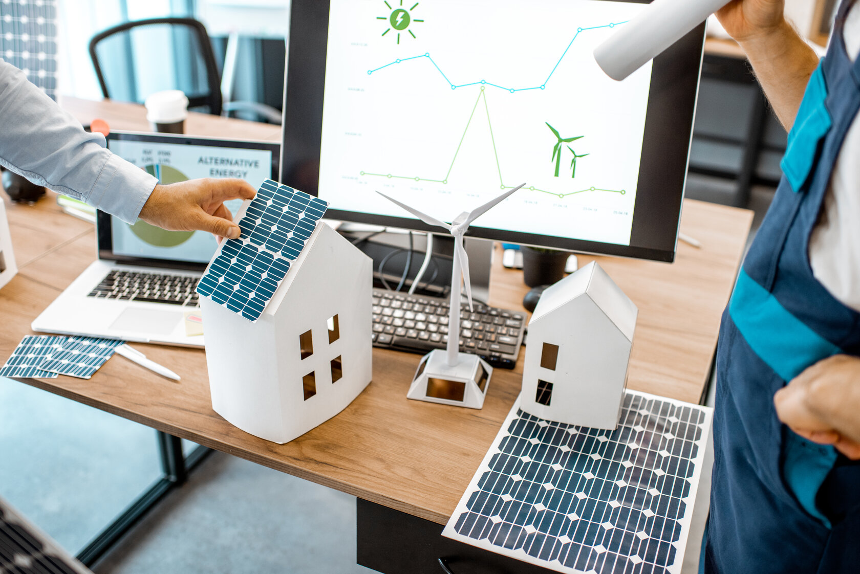 close-up of table with laptop and models of buildings and solar panels close-up of table with laptop and models of buildings and solar panels