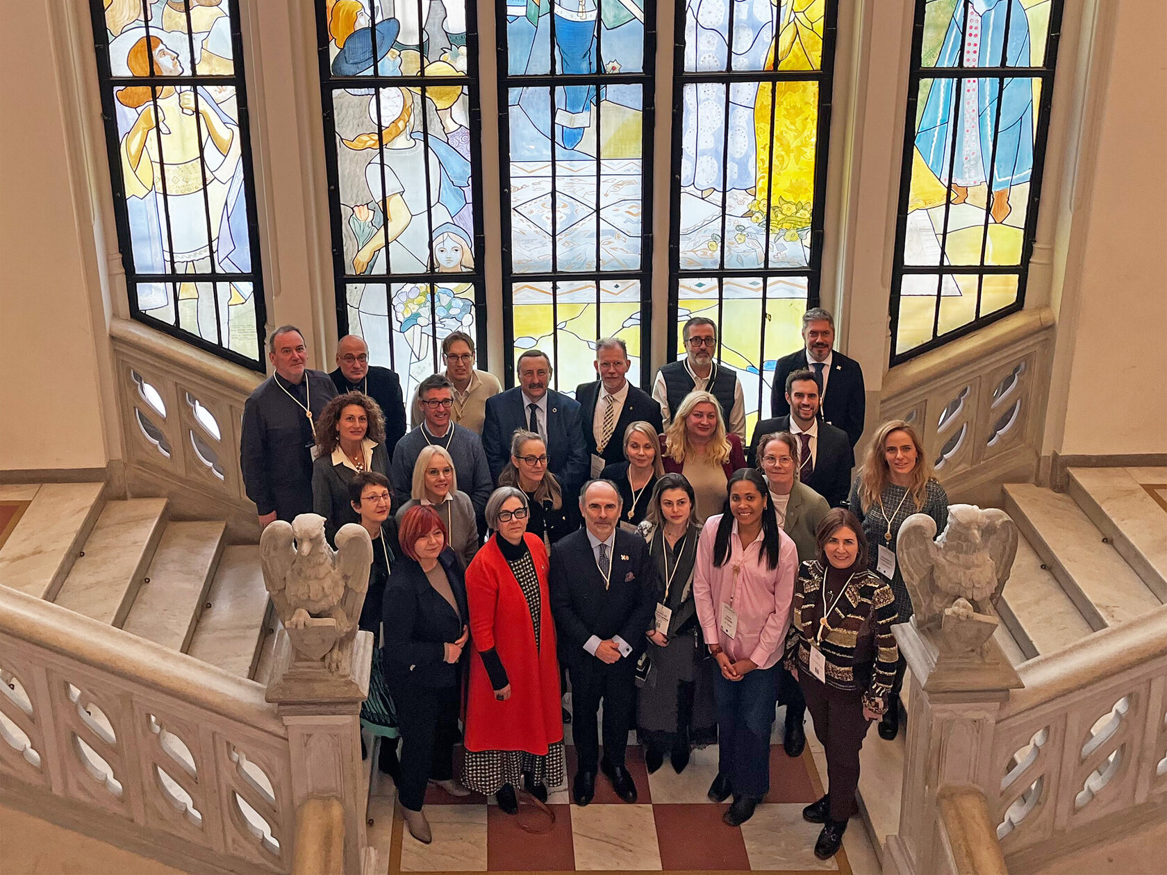 Alliance Council members standing on sweeping marble staircase
