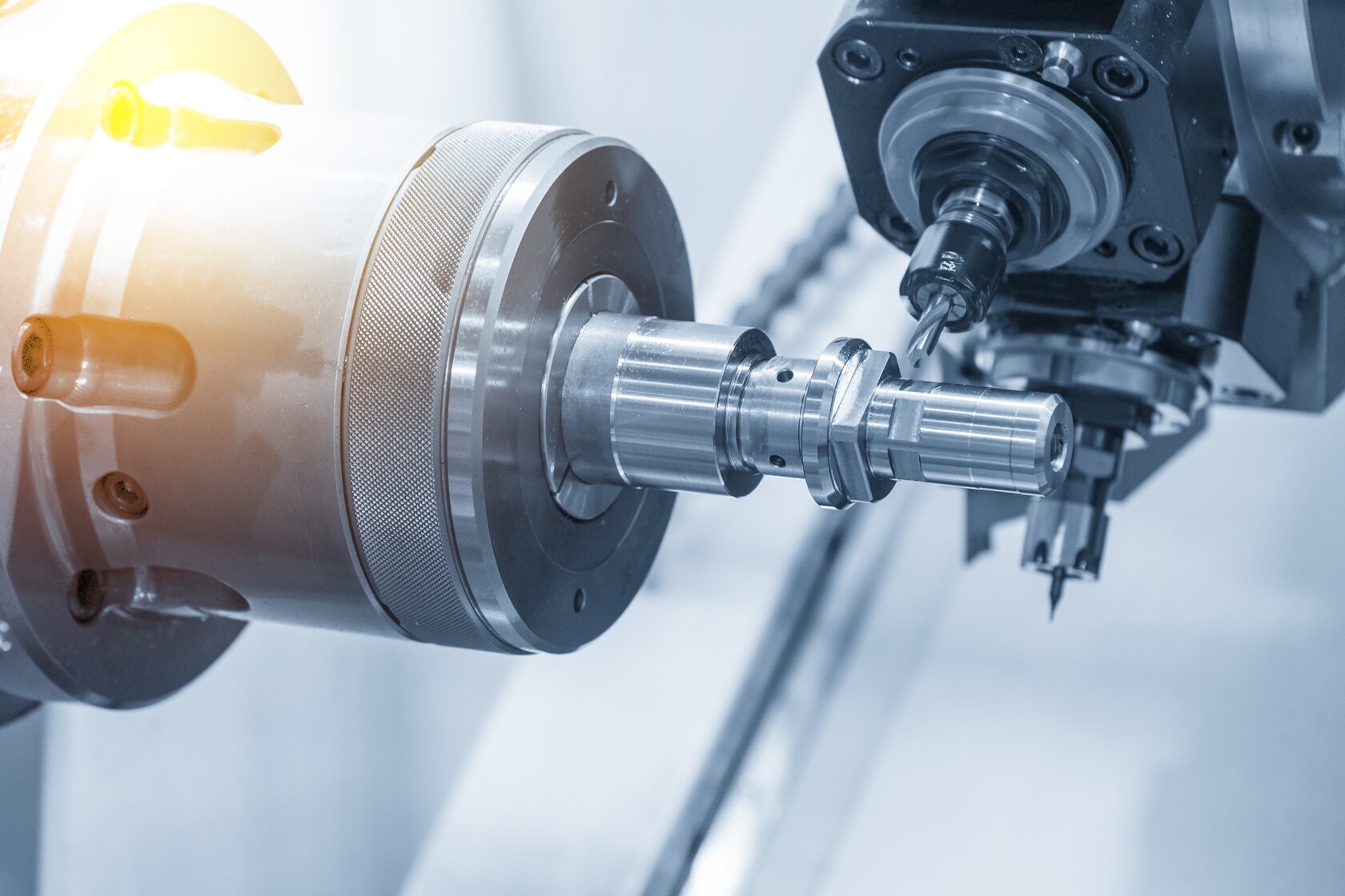 The CNC lathe machine or Turning machine drilling the metal rod with the drill tool and center drill tool. The hi-technology machining concept. The CNC lathe machine or Turning machine drilling the metal rod with the drill tool and center drill tool. The hi-technology machining concept.
