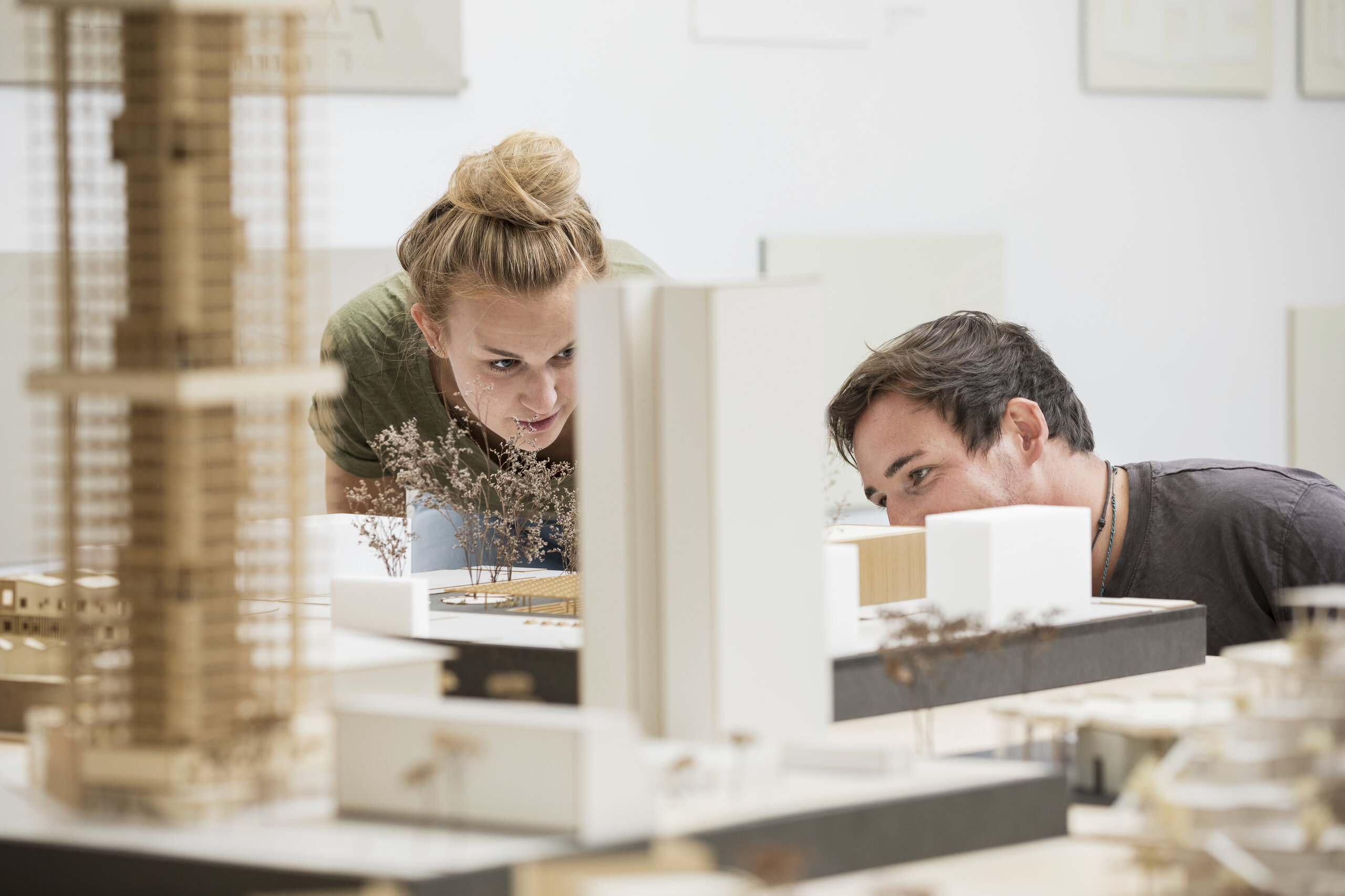 two students scrutinizing the model of a building two students scrutinizing the model of a building