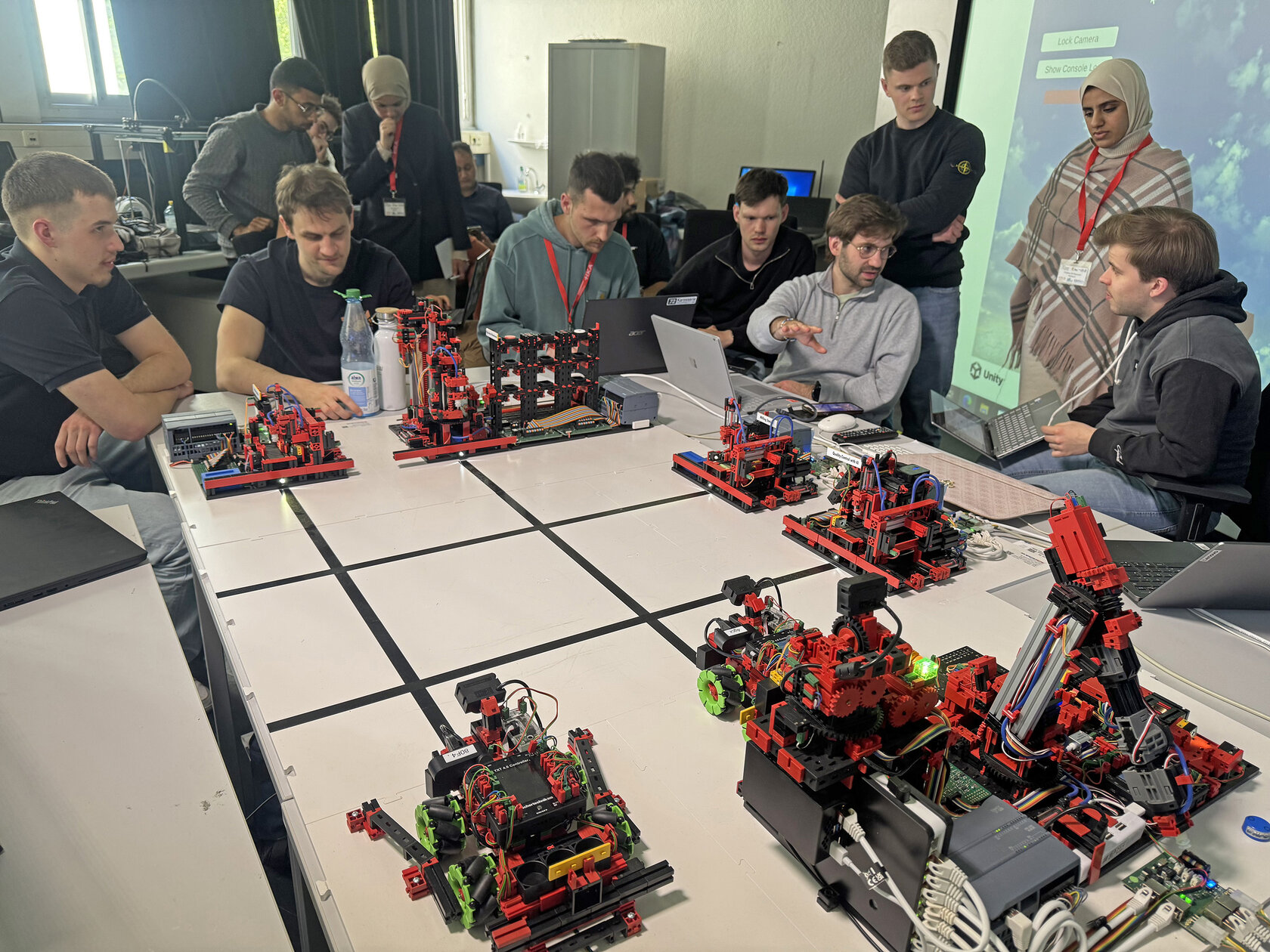 students sitting around table with little machines on it