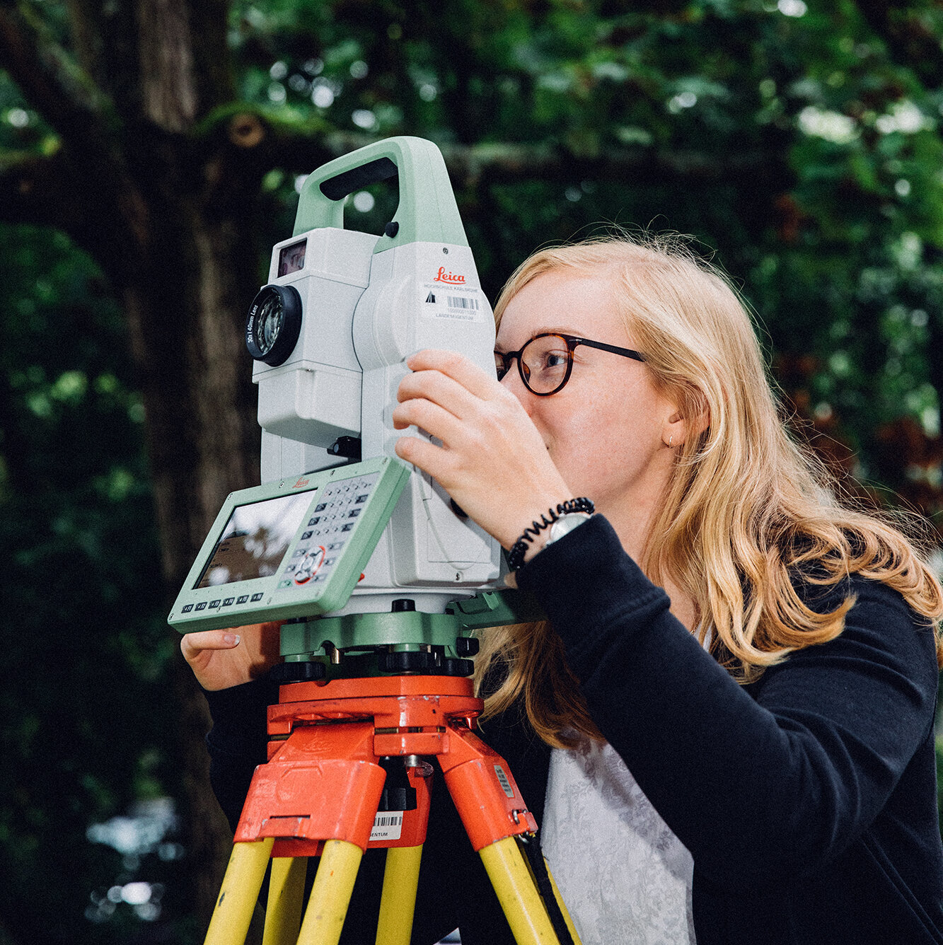 student taking measurements via theodolite student taking measurements via theodolite