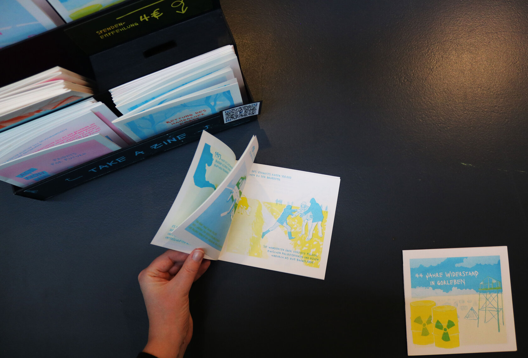 Hefte liegen auf einem Tisch, eines wird gerade durchgeblättert