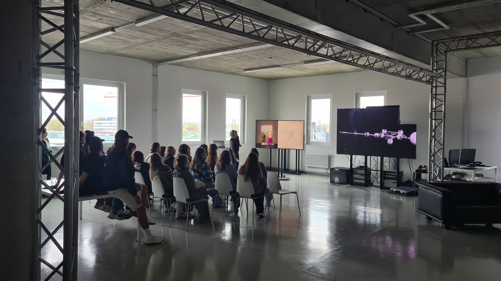 Präsentation vor Gruppe von Studierenden in einem Loft